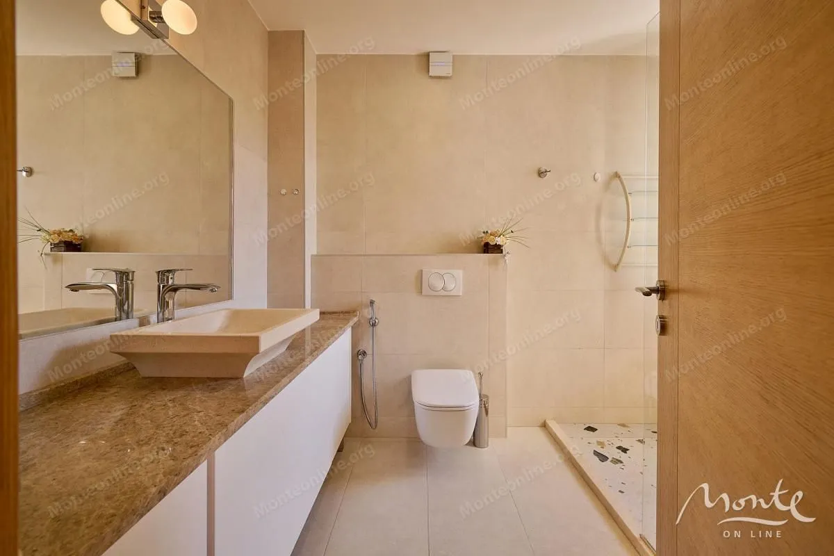 Moderne kupatilo sa umivaonikom, WC šoljom i tuš kabinom.