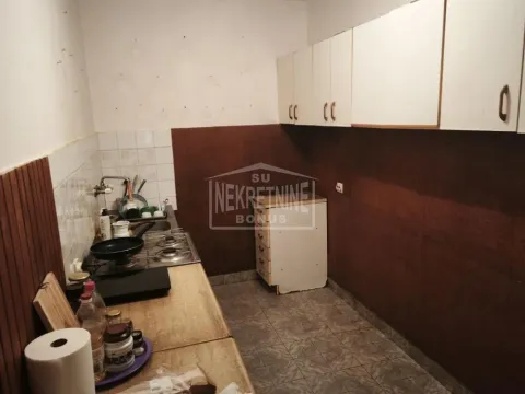 Starija kuhinja sa drvenim elementima i ugradnom pločom. - image 3