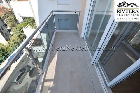 Manji popločani balkon sa staklenom ogradom i pogledom na ulicu. - image 5