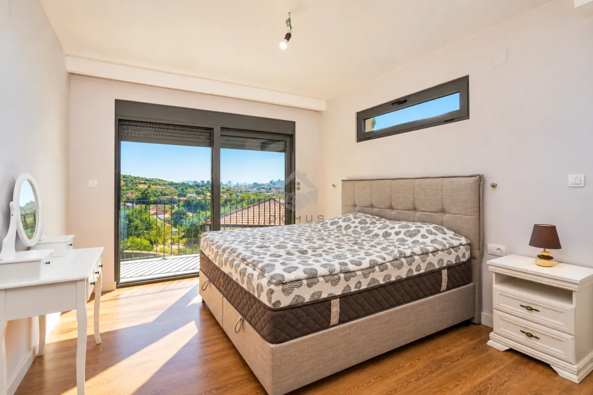 Bedroom with a double bed, white furniture piece, and access to a balcony.