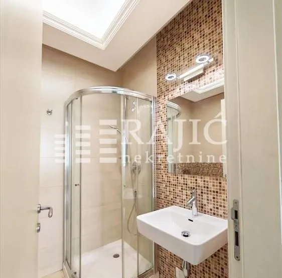 Modern bathroom with a shower cabin and sink.