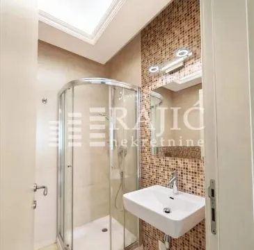 Modern bathroom with a shower cabin and sink. - image 14