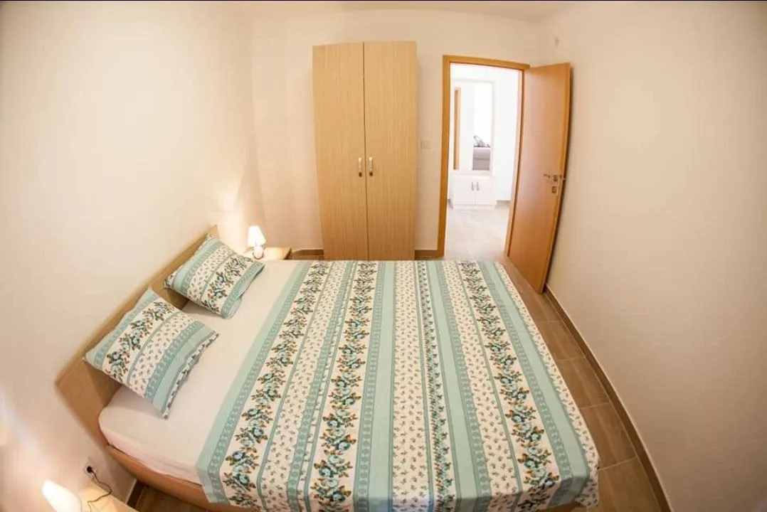 Furnished bedroom with a double bed and a wardrobe.