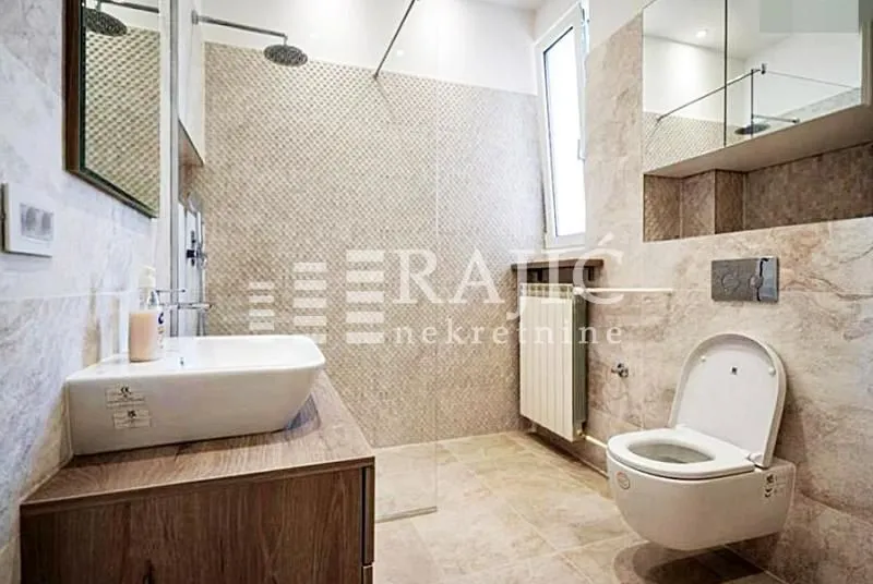 Modernly equipped bathroom with a walk-in shower and washbasin.