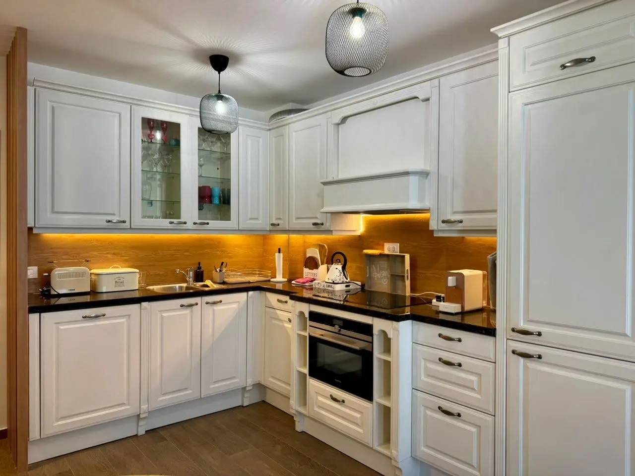 Modern white kitchen with built-in cabinetry and countertops.