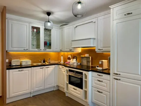 Modern white kitchen with built-in cabinetry and countertops. - image 7