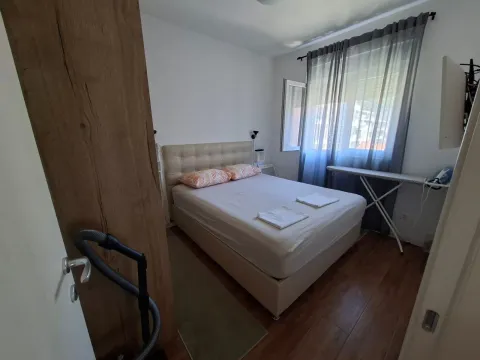 Smaller bedroom with a double bed, window, and wooden flooring. - image 5