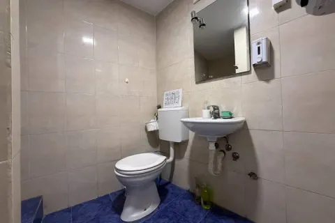 Small bathroom with a toilet, washbasin, and wall mirror. - image 9