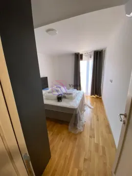 Spavaća soba sa krevetom prekrivenim zaštitnom folijom i parketom na podu. - image 10