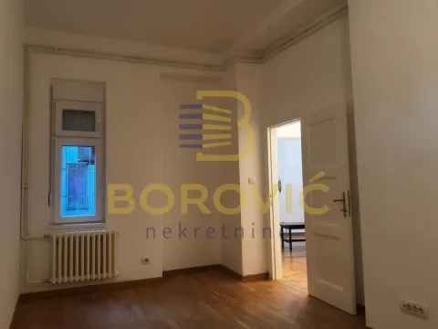 Prazna prostorija sa drvenim podom, belim zidovima i vratima koja vode u drugu prostoriju. - image 8