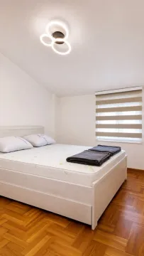 Bright bedroom with a double bed and parquet flooring. - image 6