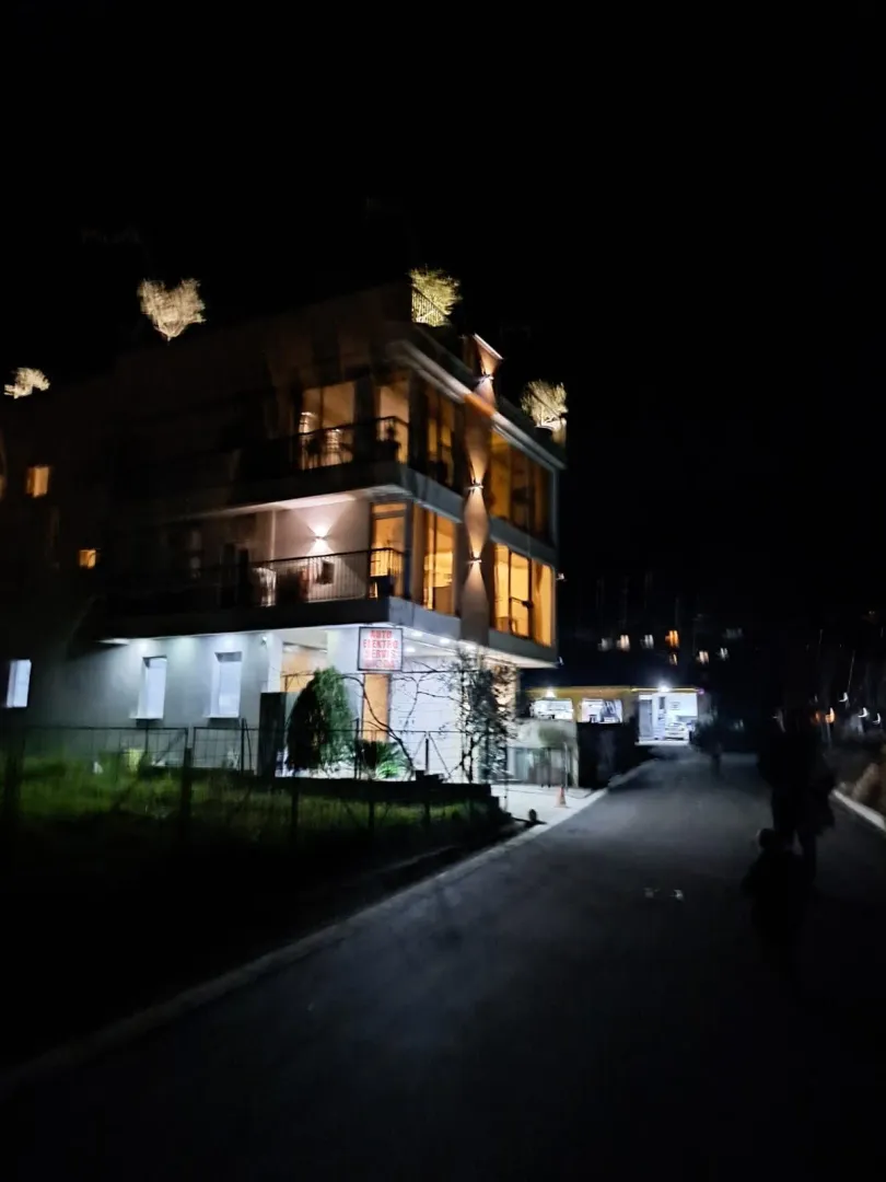 Noćni izgled spoljašnjosti stambene zgrade sa osvjetljenjem.