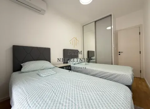 Bedroom with two single beds, wardrobe, and air conditioning. - image 8