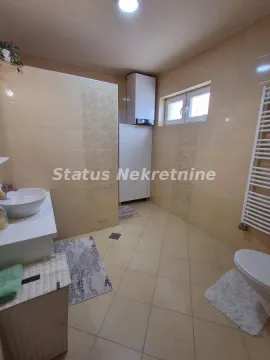 Prostrano kupatilo sa tuš kabinom, umivaonikom i wc šoljom obloženo keramičkim pločicama. - image 17