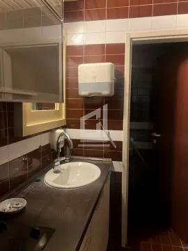 Small bathroom with a washbasin, mirror and brown tiles. - image 7