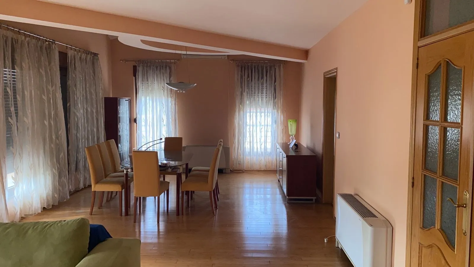 Svijetla i prostrana trpezarija sa velikim stolom i udobnim stolicama.