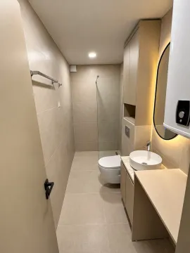 Moderno opremljeno kupatilo sa tuš kabinom, umivaonikom i ugradnim elementima u bež tonovima. - image 4