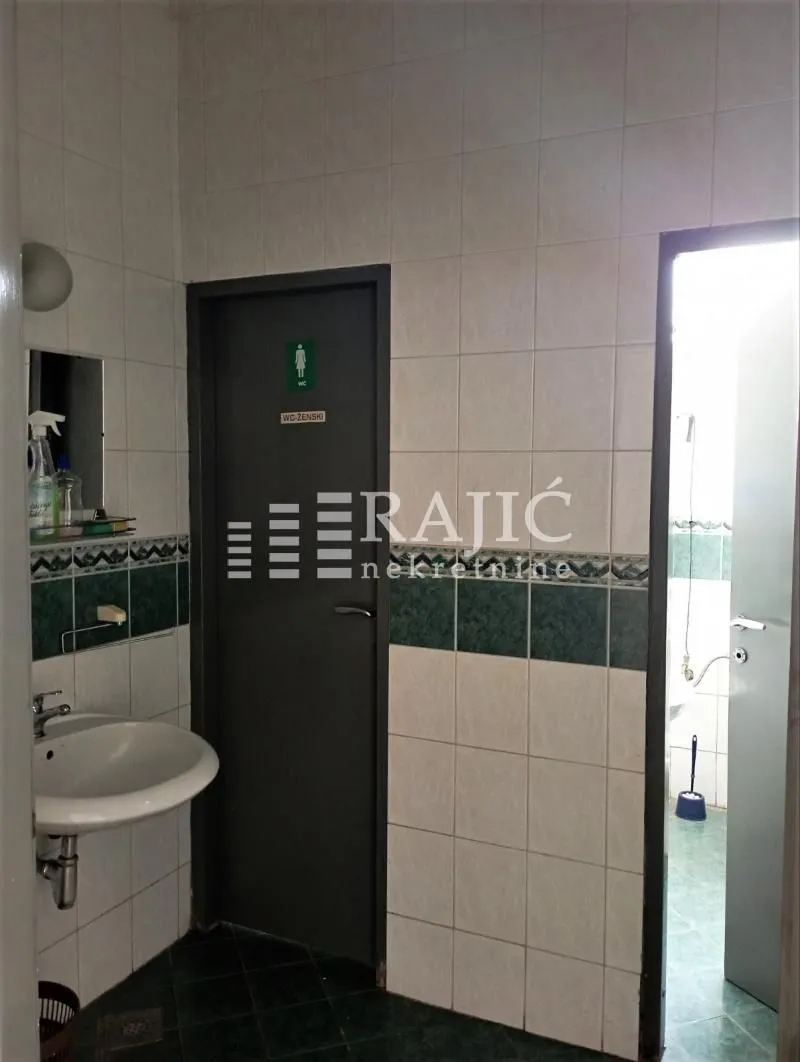 View of the bathroom with a washbasin and ceramic tiles.