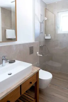 Savremeno opremljeno kupatilo sa umivaonikom, tuš kabinom i wc šoljom. - image 3
