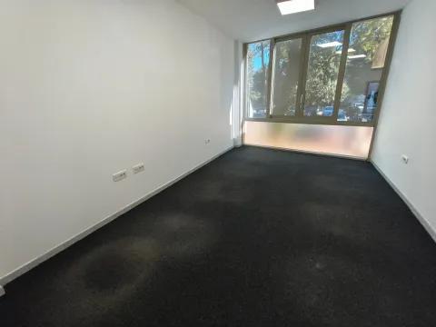 Empty office room with dark carpet and a large window. - image 5