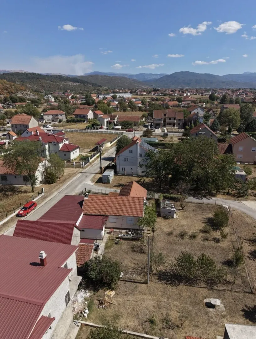 Pogled iz vazduha na kuću sa dvorištem i okolnim naseljem.