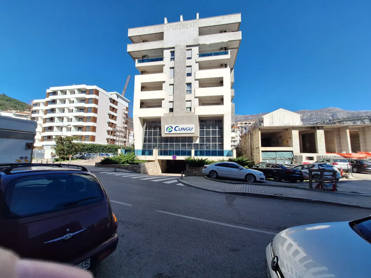 Exterior of a multi-family residential building with parking in front.