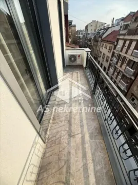 Long balcony with metal railing and view of city buildings. - image 11
