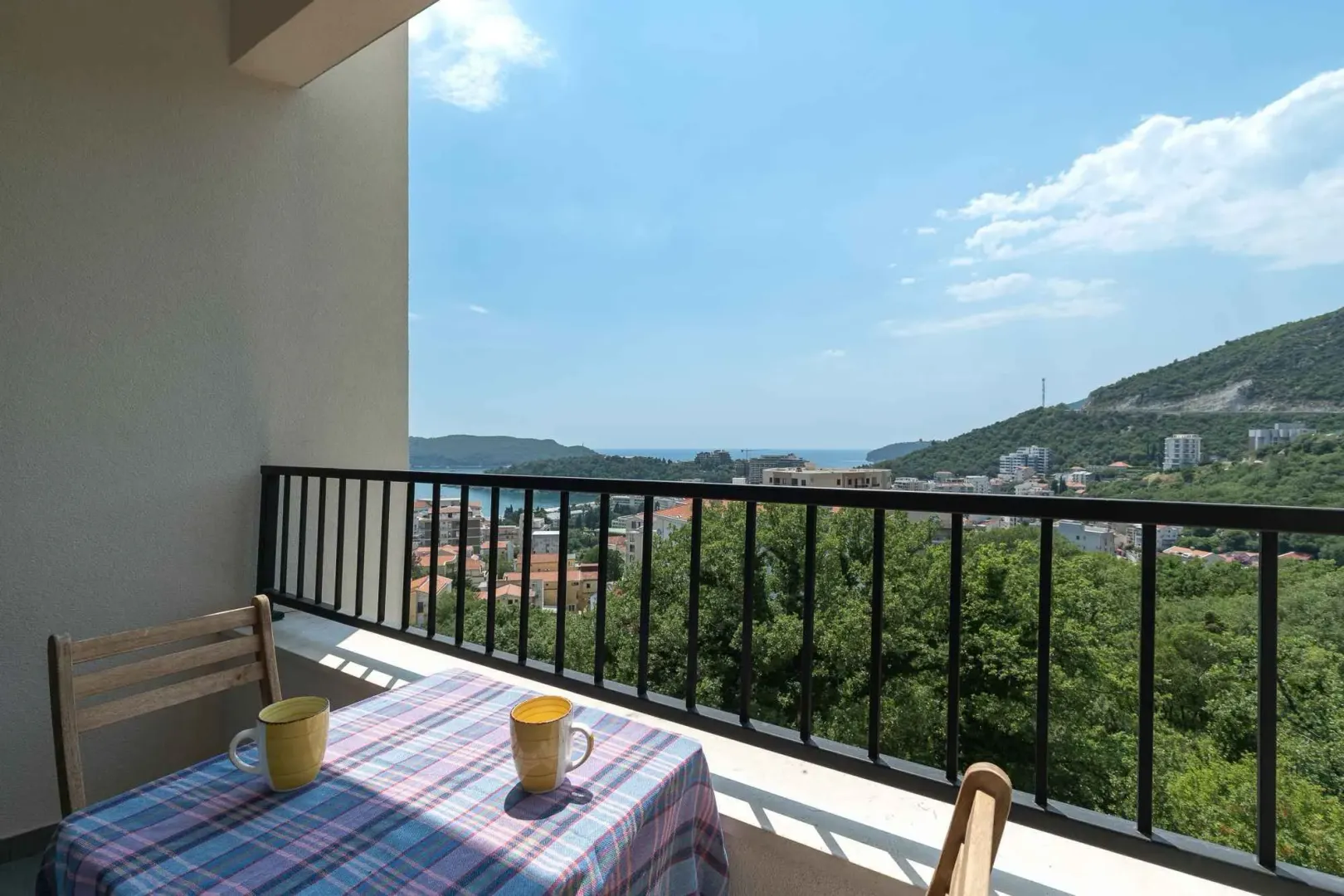 Furnished balcony with a table and a view of the sea and nature.
