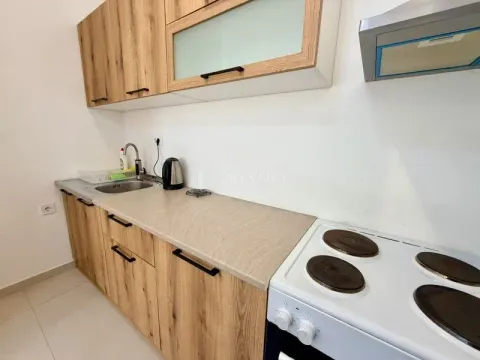 Small kitchen with wooden elements and a stove. - image 5
