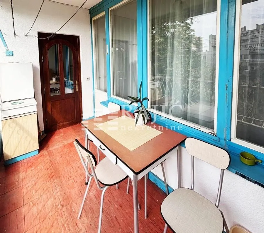 Enclosed balcony with a dining table and chairs.