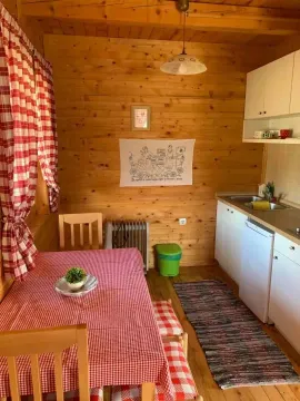 Manja drvena kuhinja sa trpezarijskim stolom i crveno-bijelim kariranim detaljima. - image 7