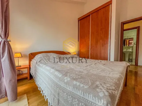 Furnished bedroom with a double bed, wooden wardrobe, and bedside lamps. - image 9