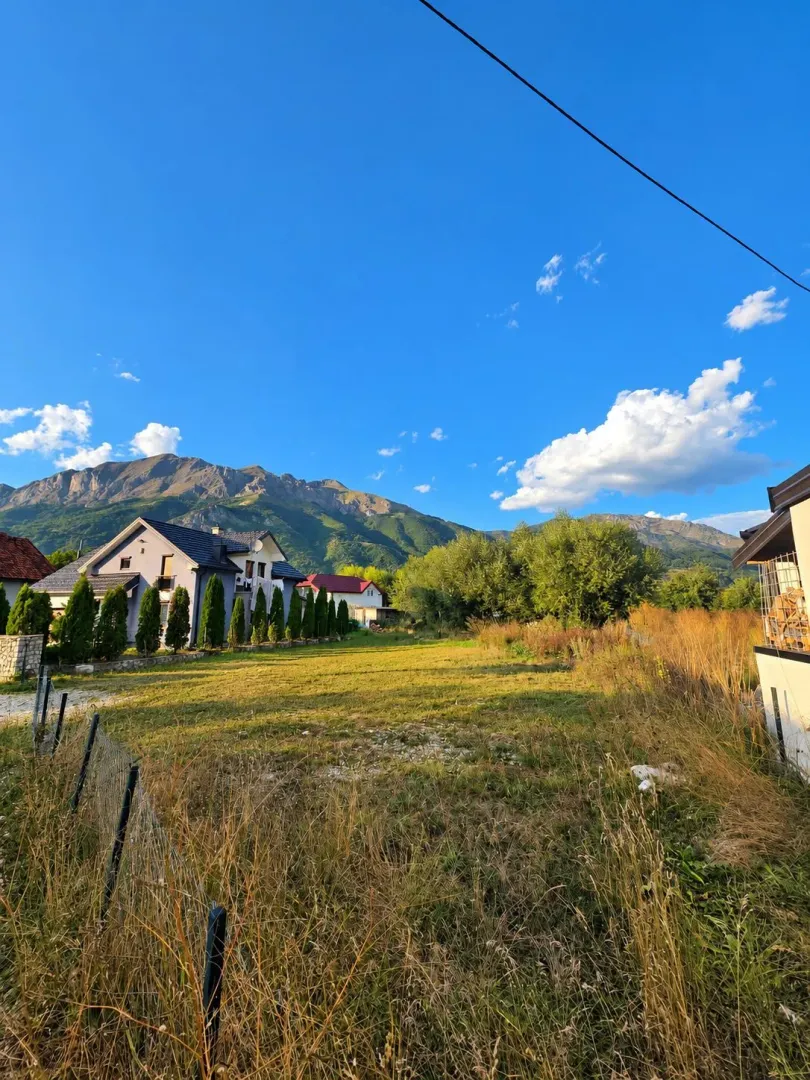 Pogled na dvorište i okolne kuće sa planinama u pozadini.