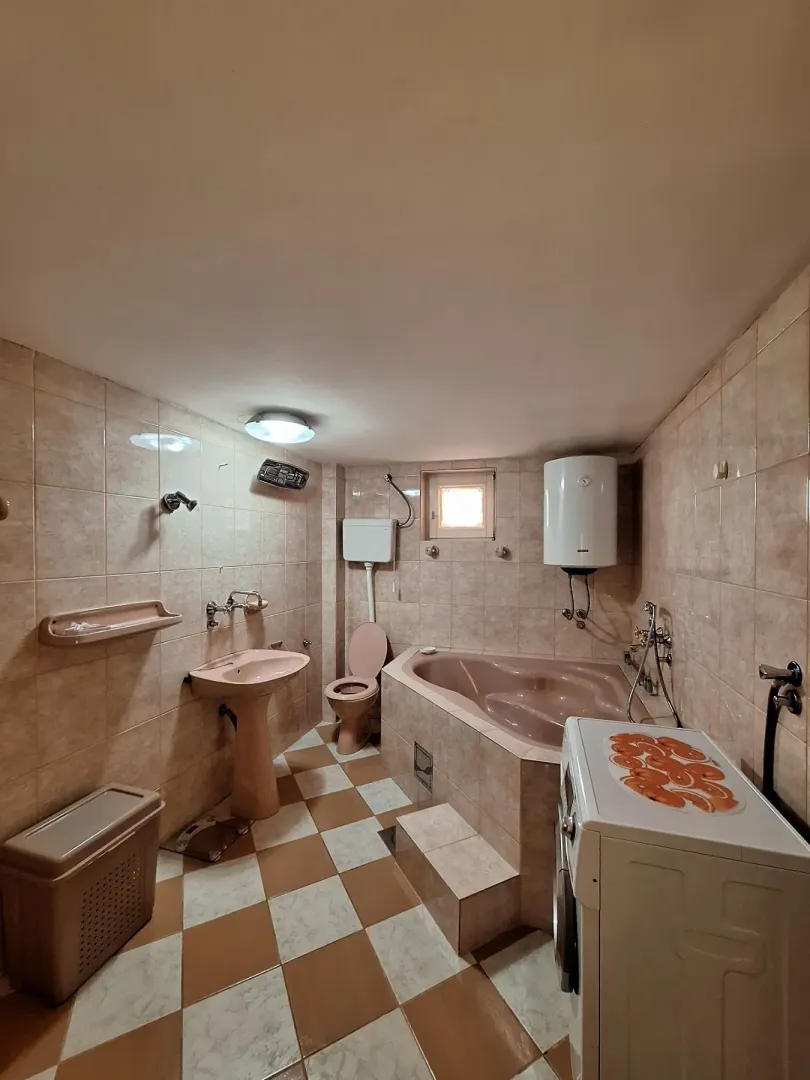 A bathroom with a bathtub, sink, and washing machine.