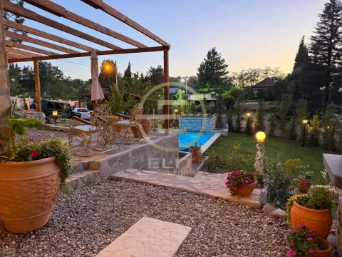 Pogled na dvorište sa bazenom, terasom i pergolom u sumrak. - image 3