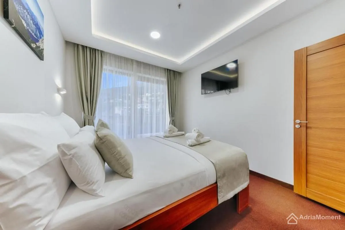 Furnished bedroom with a double bed, TV, and access to the terrace.