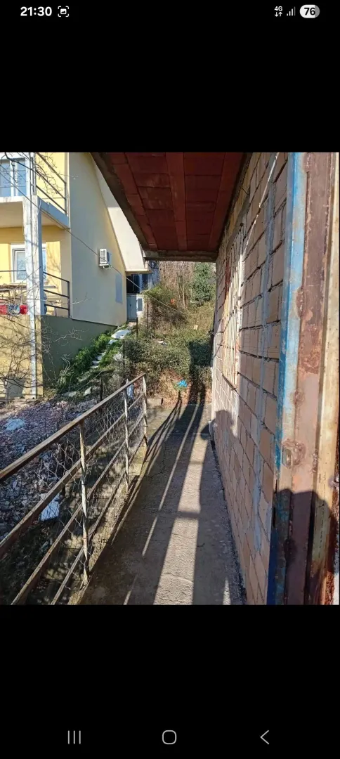 Eksterijer kuće sa prolazom i pogledom na dvorište.