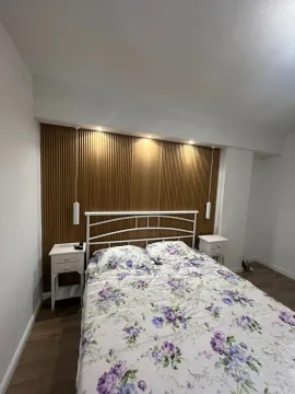 Spavaća soba sa bračnim krevetom i drvenim zidnim panelom. - image 8