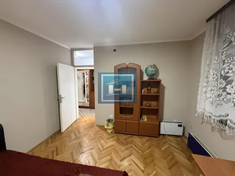 Furnished bedroom with wooden parquet flooring and a wardrobe. - image 11