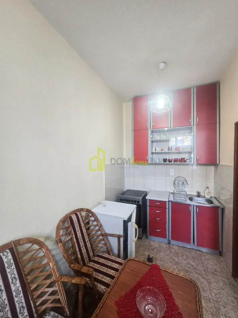 Small kitchen with red cabinets and a dining area.