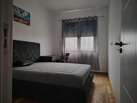 Jednostavno namještena spavaća soba sa bračnim krevetom i radnim stolom pored prozora. - image 3