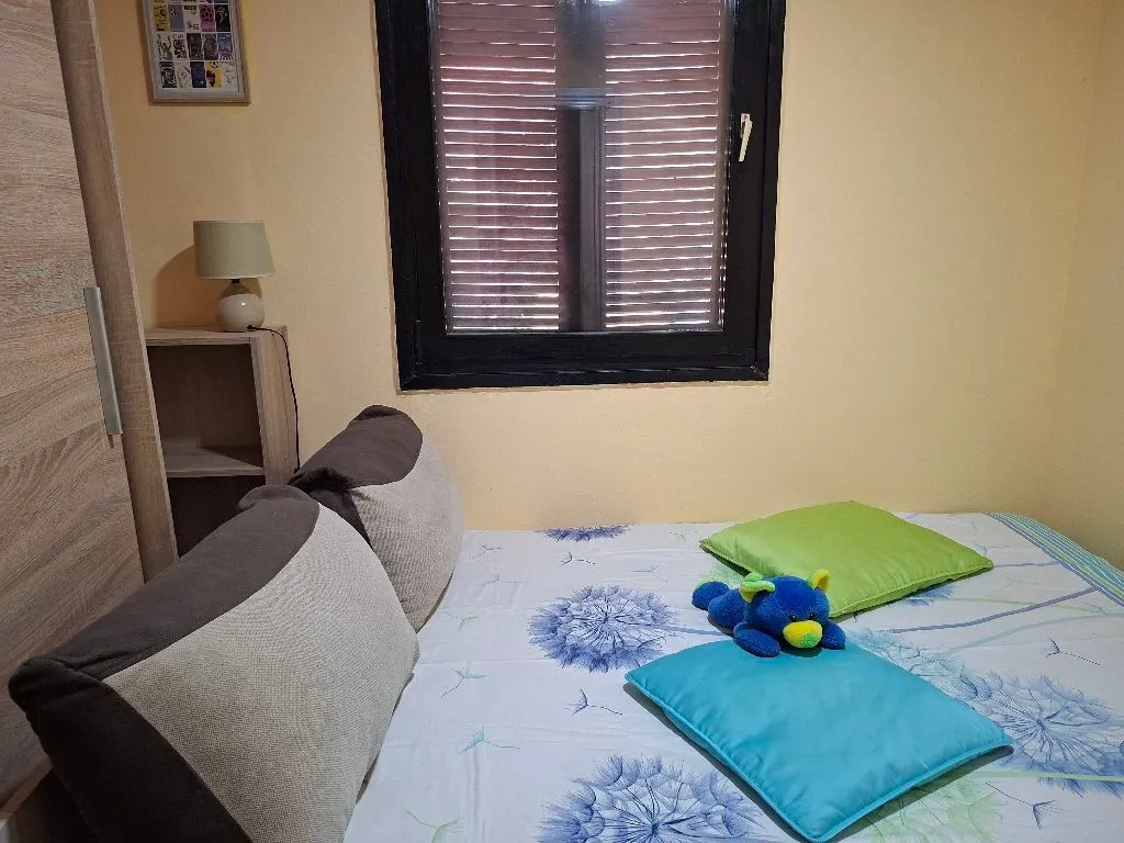 Small bedroom with a double bed, wardrobe, and a window.