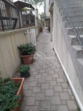 Popločani prolaz pored objekta sa stepeništem i žardinjerama. - image 18