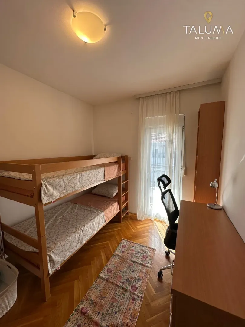 Children's bedroom with a bunk bed, desk, and access to the terrace.