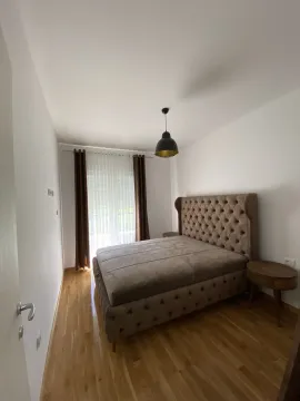 A bright bedroom with a double bed and wooden floors. - image 19