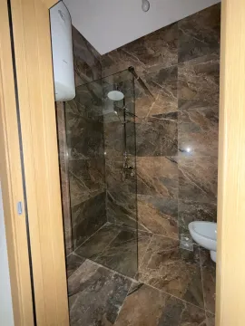 Moderne kupatilo obloženo mermernim pločicama sa tuš kabinom. - image 6