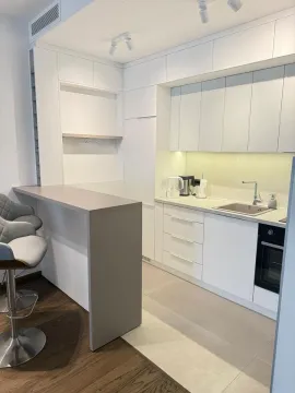 Modern white kitchen with a breakfast bar and bar stools. - image 6
