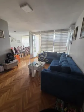 Spacious living room with a blue sectional sofa and a dining area in the background. - image 3