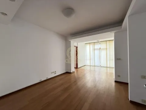 Empty living room with hardwood flooring and a large window. - image 12