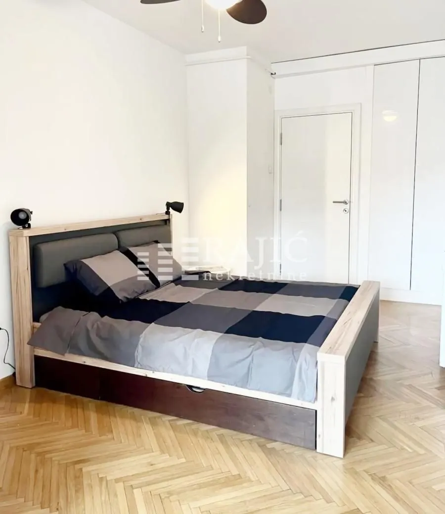 Bedroom with a double bed, parquet flooring, and a built-in wardrobe.